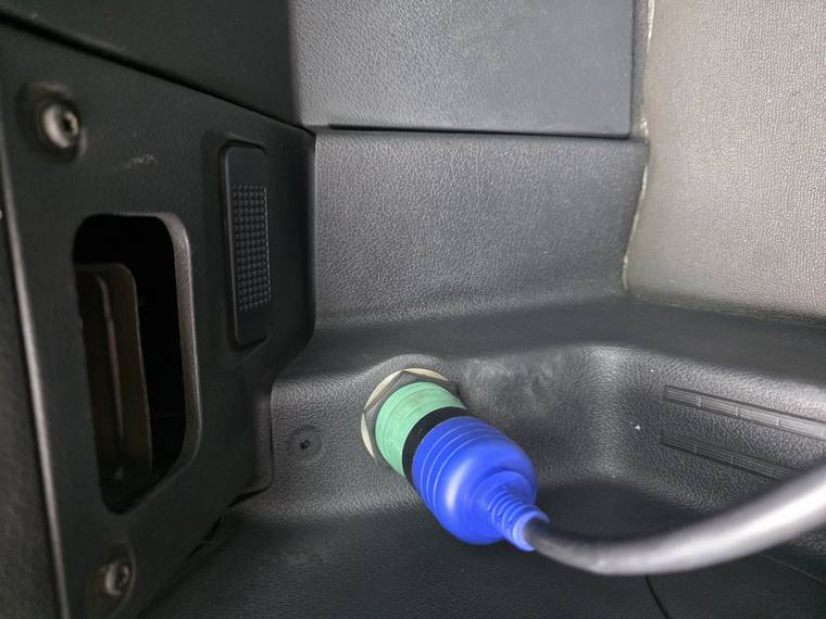 Testing equipment connected to a heavy-duty truck's diagnostic port in the cab